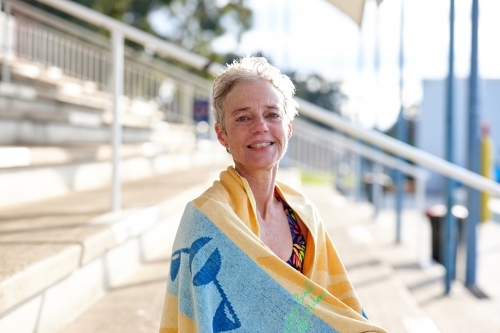 Active senior lady with towel at swimming pool