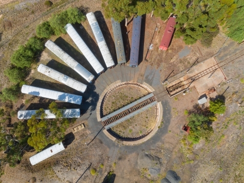Aerial view of long train carriages lined up around a railway turntable