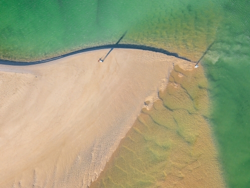 Aerial view of sandbars and waves at the mouth of a tidal river