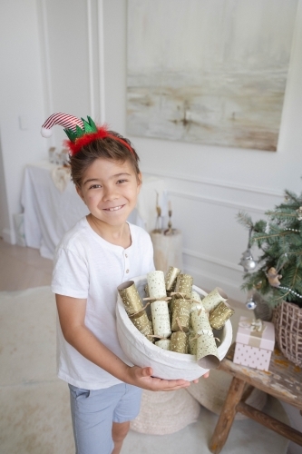 Boy holding bowl of Christmas crackers