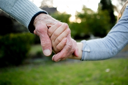 Close-up of aged and young hands holding each other