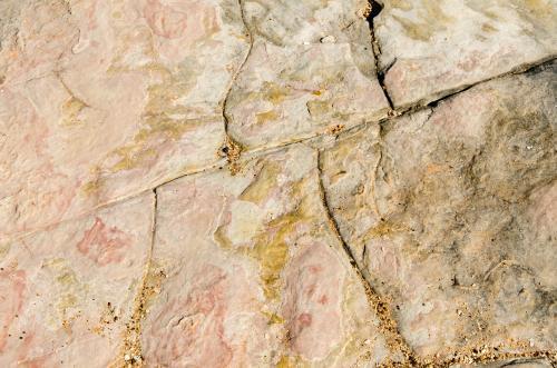 Close up of marbled rock with cracks and pink colours
