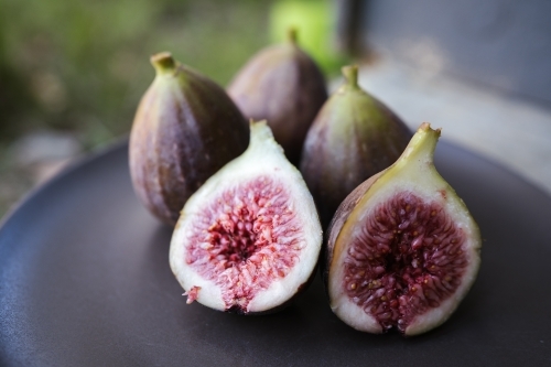Cut figs on a dark coloured plate