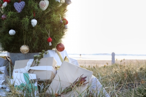 Decorated Christmas tree with presents and beach in background