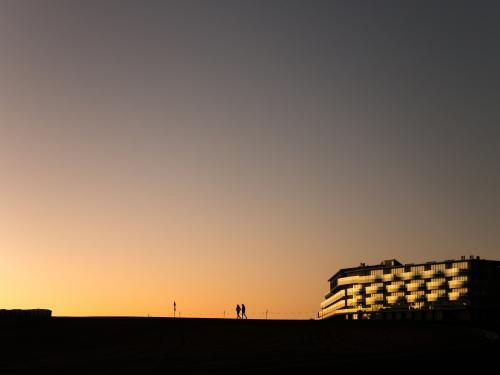 Dusk silhouette of 2 walkers and a hotel on Mt Panorama Racing Circuit