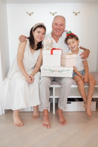 Family photo of grandad with grandkids and Christmas presents