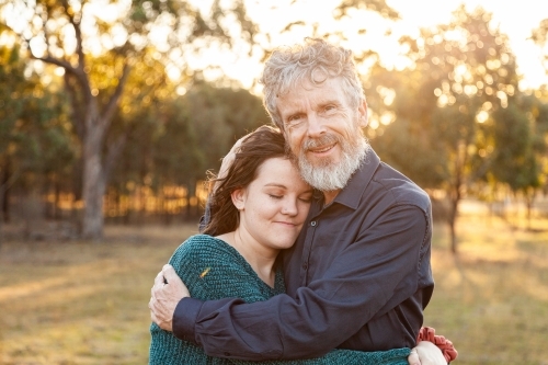 Father and daughter hug in afternoon light