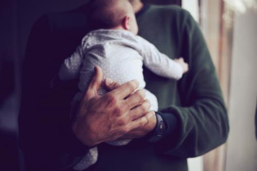 Father holding baby on chest