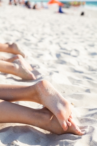 Feet of person relaxing in beach sand