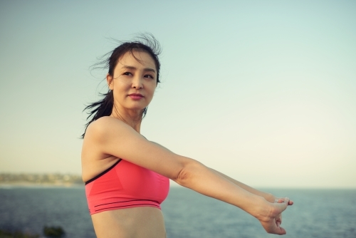 Fit woman stretching outside for morning exercise