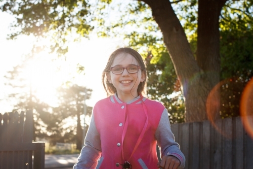 Girl smiling and walking toward camera at dusk