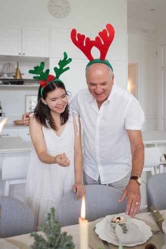 Grandfather and granddaughter standing at Christmas dining table
