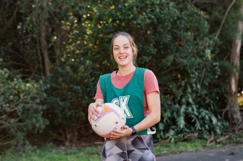 Horizontal shot of a woman holding a ball smiling while looking at the camera