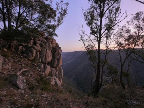 Large granite rockface on the edge of a gorge at dusk