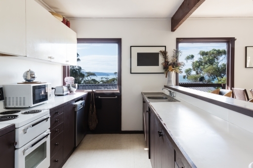 Older style retro 70s kitchen in Australian beach house with a view