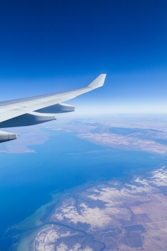 Plane wing over coastal Australian waters on long distance flight