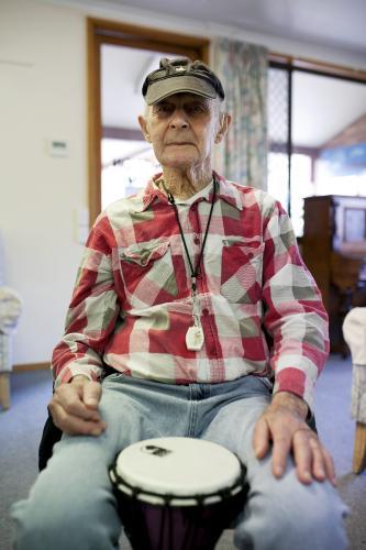 Portrait of elderly man during bongo drumming session at retirement village