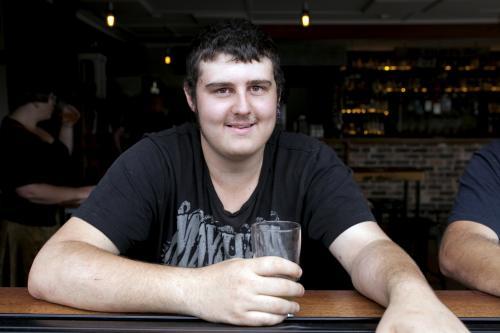 Portrait of young man having a drink at pub