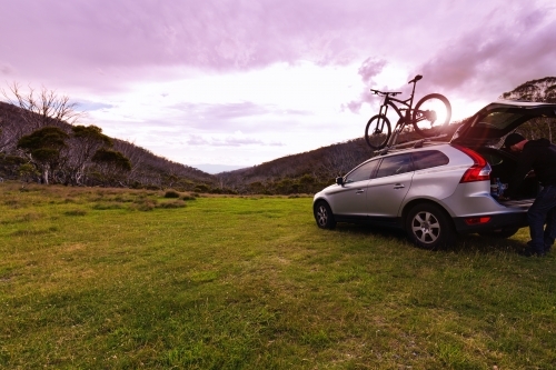 Purple sunset at Dead Horse Gap with SUV and mountain bike on top