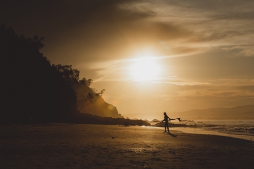 Silhouette of surfer at dawn