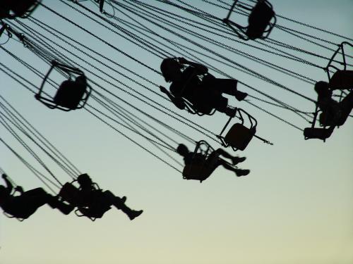 Silhouetted people in the air on a big Merry-Go-Round