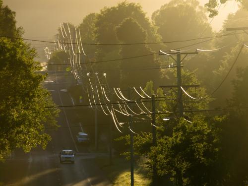 Sunlight reflected off power lines in a suburban street