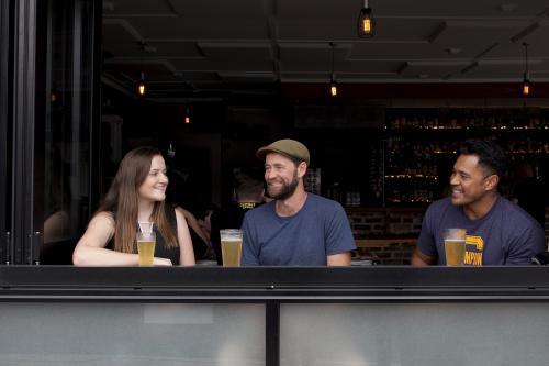 Three people sitting having a drink at a local craft beer bar