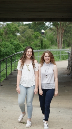 Two teenage girls walking towards camera