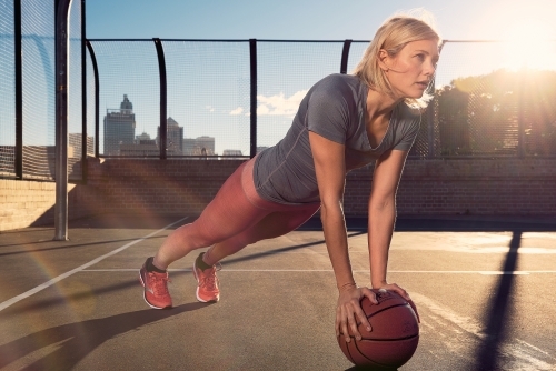 Woman training with basketball in morning light