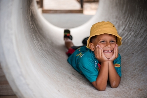 Young Aboriginal boy lying in a tunnel