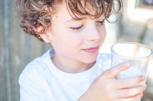 Young boy holding a glass of milk