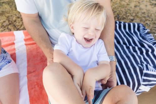 Young boy laughing as dad tickles him