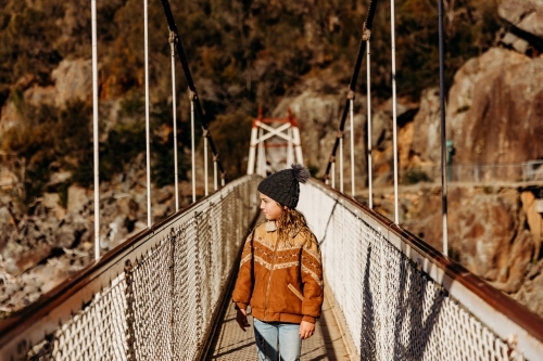 Young child walking across bridge on bush walk