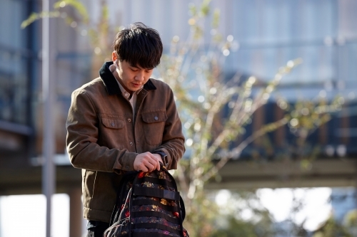 Young Chinese student outdoors with backpack