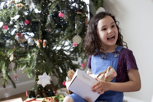 Young girl smiling and happy after opening Christmas present
