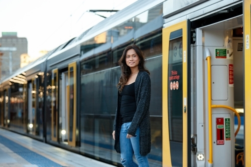 Young woman getting off train at train station