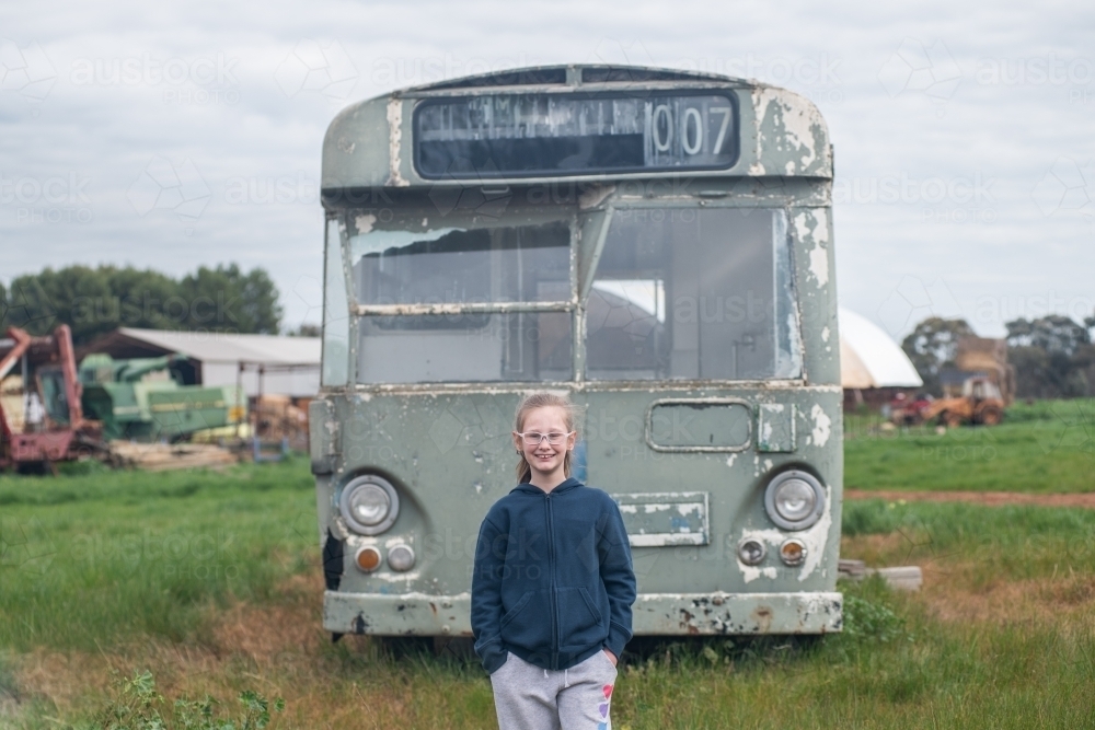 10 year old standing in front of old bus - Australian Stock Image