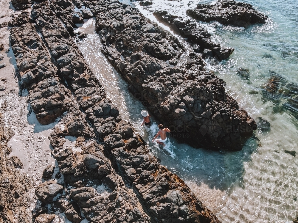 2 boys running in the water in rock pools - Australian Stock Image