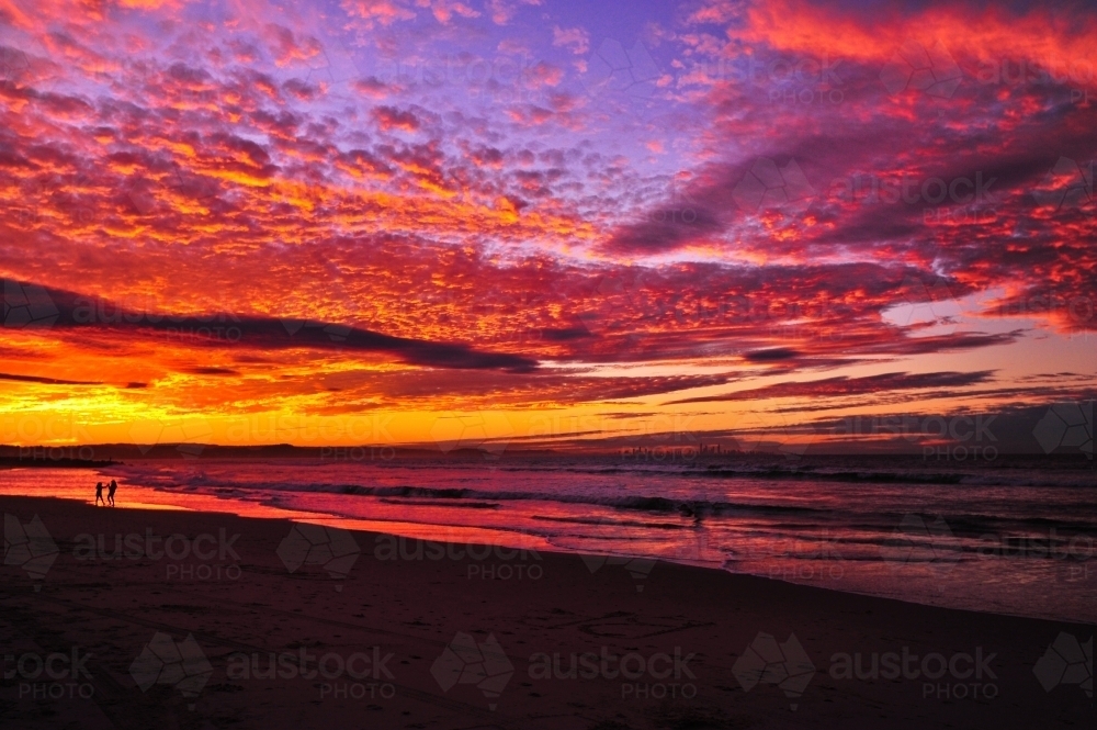 2 children play along the beach at sunset - Australian Stock Image