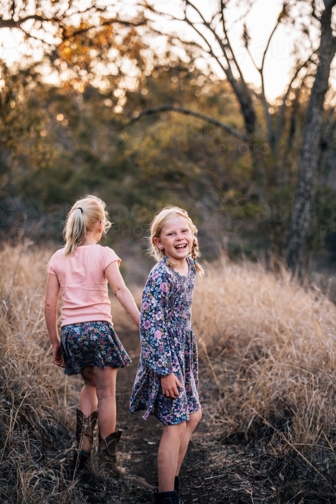 2 young girls walking down a dirt path - Australian Stock Image