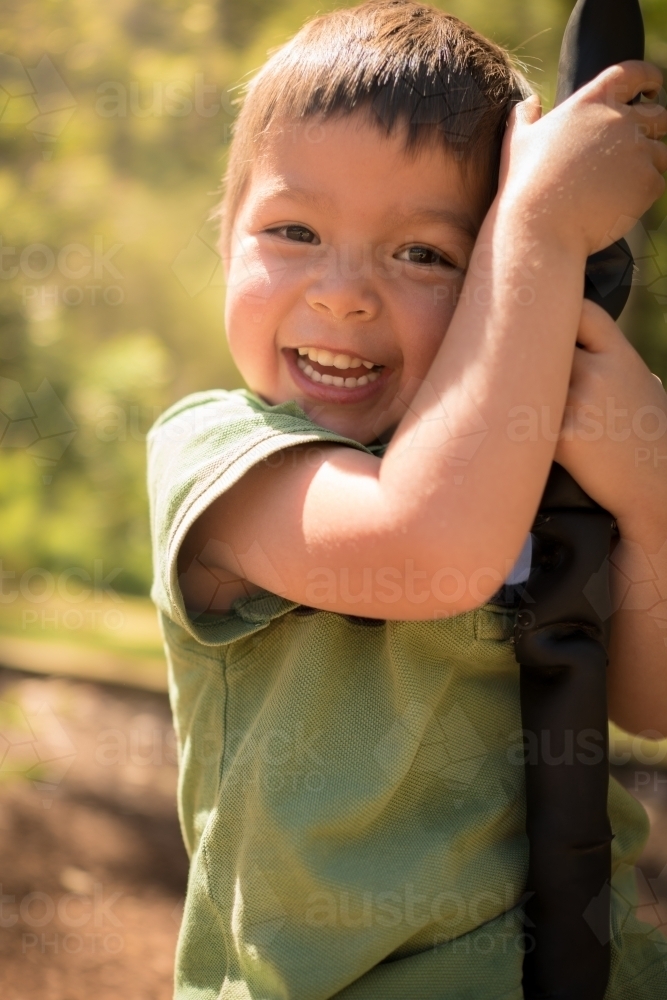 4 year old mixed race boy plays on a flying fox - Australian Stock Image
