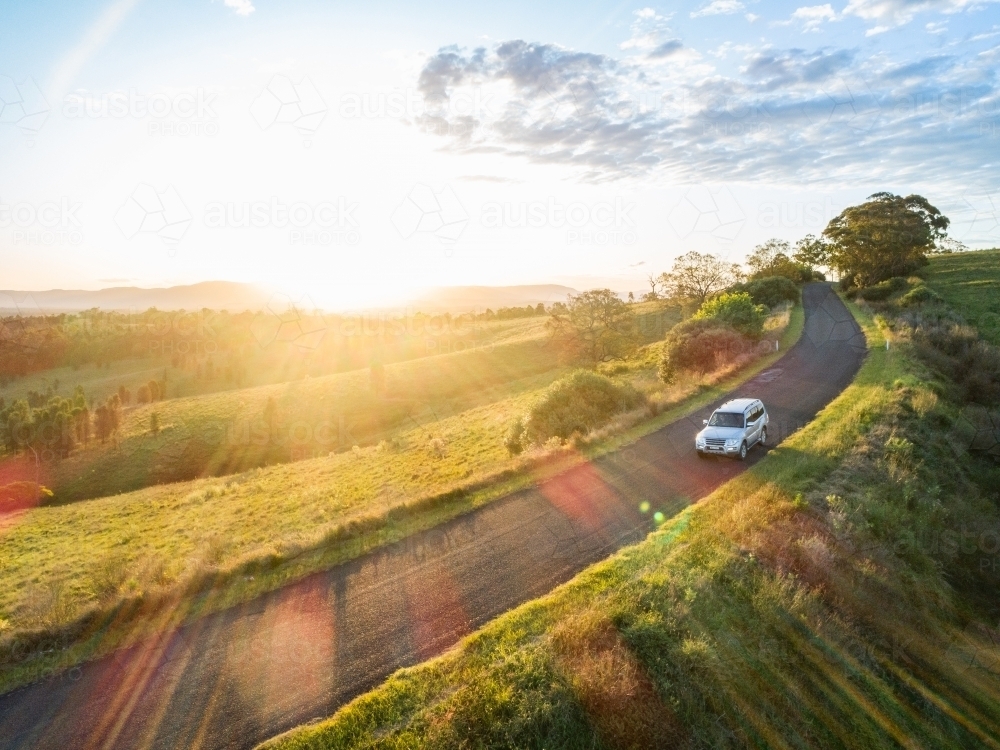 4x4 car driving on country road trip adventure on narrow road at sunset - Australian Stock Image