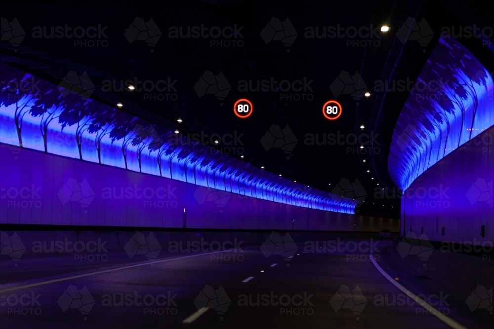 80 speed limit signs and blue lights on walls of tunnel beneath Sydney - Australian Stock Image