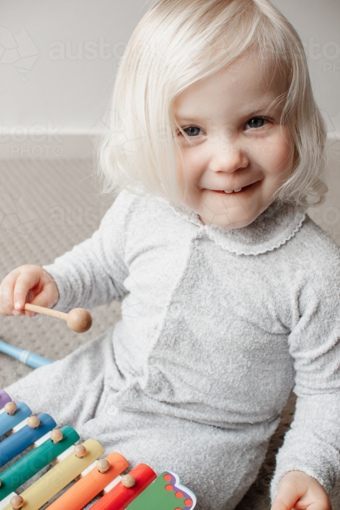 A blonde haired blue eyed two year old caucasian girl wearing a traditional Australian grow suit - Australian Stock Image