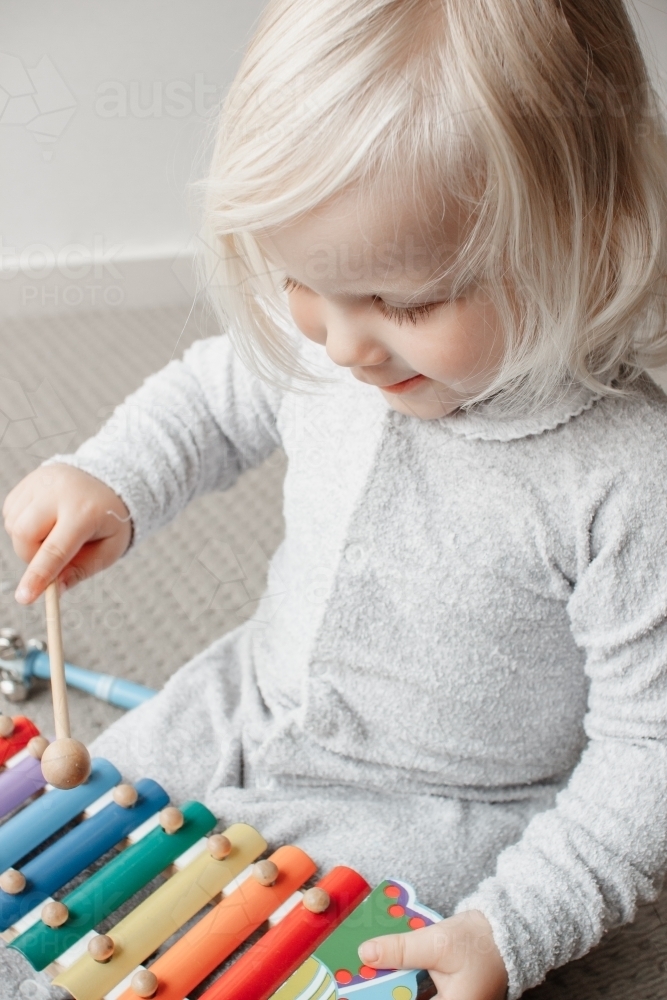 A blonde haired blue eyed two year old caucasian girl wearing a traditional Australian grow suit on - Australian Stock Image