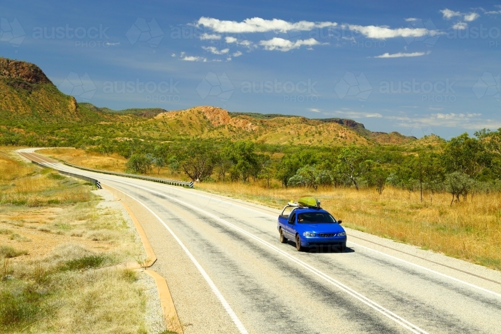 A blue ute driving on the Great Northern Highway in the Kimberley region - Australian Stock Image