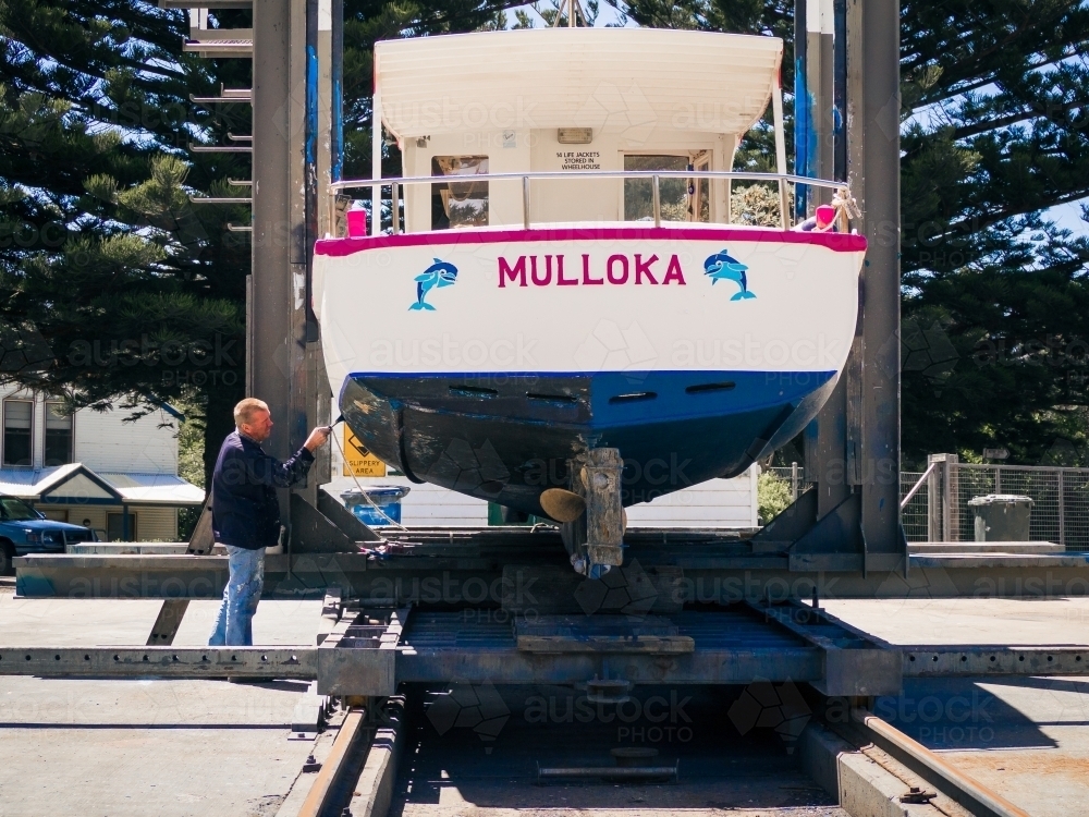 A boat getting a paint job up in dry dock - Australian Stock Image