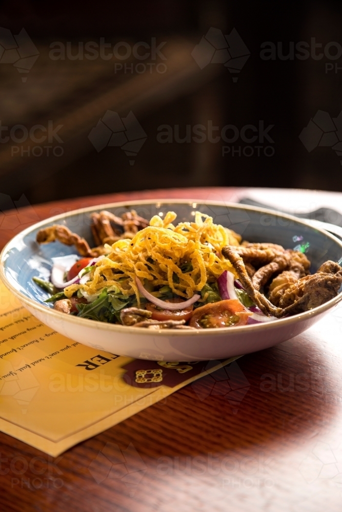 A bowl of soft shell crab salad at a restaurant - Australian Stock Image