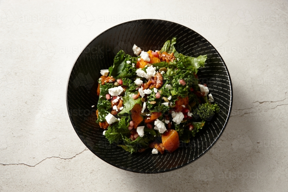 a bowl of vegetable salad topped with cheese and nuts - Australian Stock Image