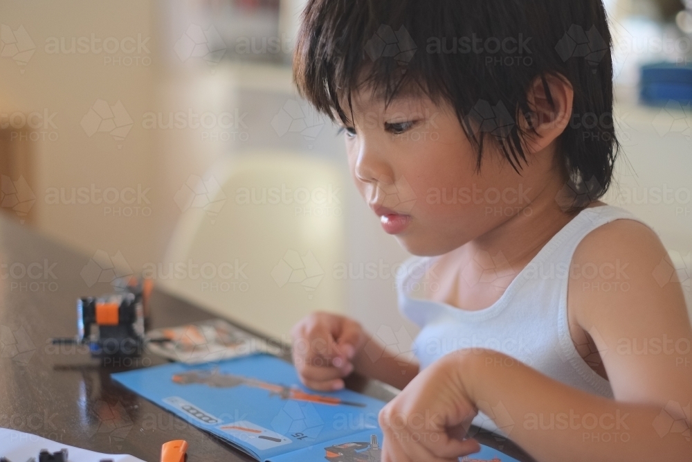 a boy, building a Lego formula race car - Australian Stock Image
